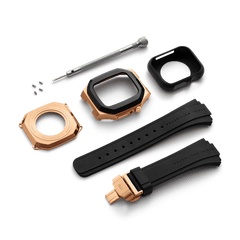 Switch Rose Gold Apple Watch case kit featuring brushed rose gold stainless steel components, a bold black bezel, black FKM rubber straps with deployment clasp, screws, screwdriver, and protective cover, all laid out for easy installation.