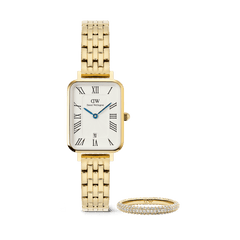Rectangular gold women’s watch with a five-link bracelet, white dial, Roman numerals, blue hands, and date display, paired with a slim gold pavé ring set with sparkling crystals.