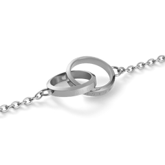 Close-up of the Elan Unity Necklace Silver pendant, showing two polished interlocked rings engraved with subtle branding on a fine silver chain.