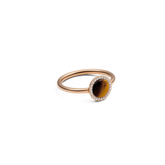 A slim rose gold ring featuring a domed tiger eye stone at the centre, surrounded by a halo of sparkling white cubic zirconia crystals, set on a polished band.