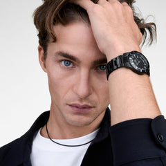 A man wearing the Iconic Paradigma Link Black watch, showing its bold black dial, index bezel, and polished link bracelet styled with a casual white t-shirt and dark shirt for a modern, everyday look.