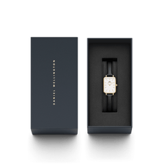 Quadro Pressed Sheffield Gold ladies watch with a rectangular gold case and black leather strap, elegantly presented in a branded Daniel Wellington gift box.