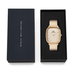 Marlon Wire Linen Rose Gold watch with a rectangular rose gold case and linen-textured dial, presented in its original Daniel Wellington gift box.
