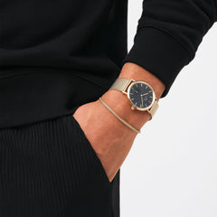 Classic Multi-Eye Evergold Onyx men's watch with a black multi-eye dial and gold mesh strap, worn with a black outfit for a modern and versatile look.