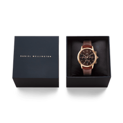 Iconic Chronograph St Mawes Amber RG men's watch presented in a premium Daniel Wellington gift box, featuring a rose gold case, amber dial, and brown leather strap.