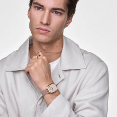Marlon Wire Linen Rose Gold watch worn on the wrist, featuring a rectangular rose gold case, linen-textured dial, and slim mesh strap, styled with a light jacket and jewellery for a modern everyday look.
