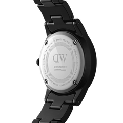 Back view of the Iconic Link Ceramic watch showing the stainless steel case back, engraved branding, and glossy black ceramic bracelet, highlighting water resistance and premium construction.