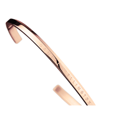 Detail view of the Classic Bracelet Rose Gold by Daniel Wellington, showing the engraved branding and polished rose gold finish on the slim stainless steel cuff.