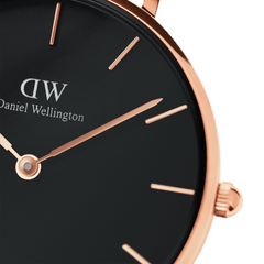 Close-up of the Petite Ashfield Rose Gold ladies watch showing the black dial, slim rose gold hands and markers, and polished rose gold case.
