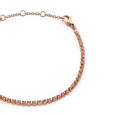 Close-up of the Classic Tennis Bracelet Apricot Rose Gold, featuring a row of apricot-coloured crystals set in rose gold with an adjustable chain and secure lobster clasp.