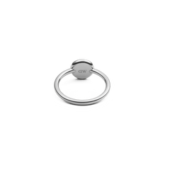 A silver ring with a smooth, polished band and a round setting, viewed from the back to show the engraved branding on the circular base.