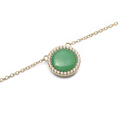 Close-up of the Audrey Necklace Jade Gold pendant, showcasing a domed green jade stone surrounded by a halo of sparkling white cubic zirconia crystals on a fine gold chain.