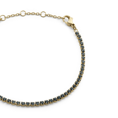 Close-up of the Classic Tennis Bracelet Nightfall Gold, showcasing its slim gold band with individually set deep-coloured Preciosa crystals and adjustable sizing rings with a lobster clasp.