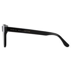 Side view of Ambler Bio-Acetate Black sunglasses showing the slim, all-black Italian bio-acetate frame with the Daniel Wellington logo in gold on the arm.