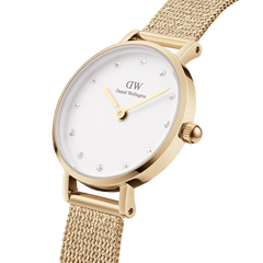 Petite Lumine Pressed Evergold gold mesh strap watch with a smooth eggshell white dial, crystal hour markers, and minimalist gold case, shown in a close-up to highlight its refined detailing and elegant finish.