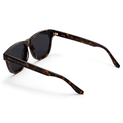 Ambler Bio-Acetate Dark Havana sunglasses shown from a rear angle, highlighting the dark tortoiseshell frame, rectangular shape, and Daniel Wellington branding on the arm.
