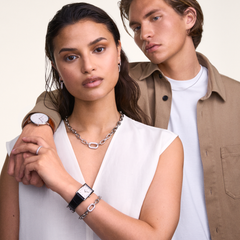 The Bound Black Crocodile Silver watch is worn on the wrist, showcasing its rectangular silver case, white dial, and black crocodile-embossed leather strap, styled with silver jewellery and a white sleeveless top for a modern, versatile look.