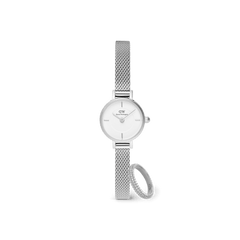 Silver Daniel Wellington Petite Mini mesh strap watch with a crisp white dial, paired with a pavé crystal ring featuring sparkling stones, both displayed against a plain background.
