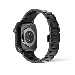 Smartwatch Iconic Link Onyx attached to the back of an Apple Watch, highlighting the durable black stainless steel bracelet and butterfly clasp.