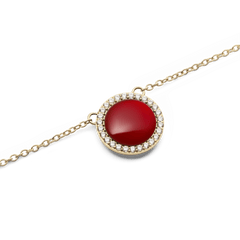 Close-up of the Audrey Necklace Red Agathe Gold pendant, showcasing a domed red agate stone set in polished gold and framed by a halo of sparkling white cubic zirconia crystals on a fine gold chain.