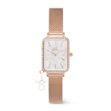 Rose gold ladies watch with a rectangular case, white mother of pearl dial, crystal border, and an interchangeable zodiac charm on an adjustable mesh strap.