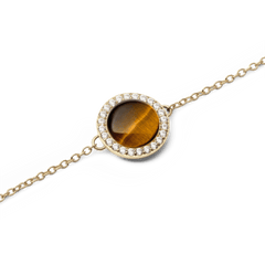 Close-up of the Audrey Bracelet Tiger Eye Gold, highlighting the round tiger eye stone at the centre, surrounded by a halo of sparkling white cubic zirconia and set on a fine gold chain.