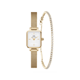 Daniel Wellington Quadro Mini watch with a gold mesh strap and rectangular white dial, paired with a gold tennis bracelet featuring sparkling stones, displayed side by side as an elegant women's accessory set.