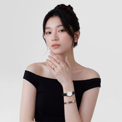 Woman wearing the Line Ring Polished Rose Gold 2.5mm on her finger, styled with a rose gold bracelet and a classic watch, highlighting the ring’s slim profile and minimalist design for everyday elegance.