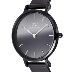 Close-up of the Daniel Wellington Petite Reflection Black watch showing the sleek black mirror glass dial, minimalist hour markers, and polished black mesh strap.