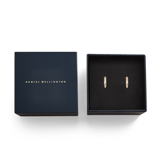 Arch Earring Rose Gold 12mm hoop earrings presented in an elegant navy Daniel Wellington gift box, highlighting the petite rose gold hoops set against a black velvet interior.