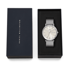 Classic Day Display Sterling Champagne men’s watch with a silver mesh strap and champagne dial, presented in a Daniel Wellington gift box, ideal for gifting or special occasions.