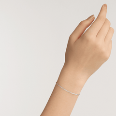 A woman’s wrist wearing the Flat Chain Bracelet S, showcasing its slim silver chain and minimalist design for a refined, everyday look.