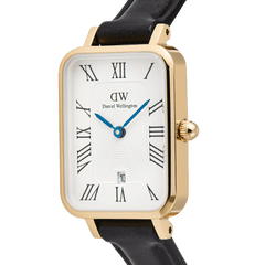Close-up of the Quadro Roman Numerals Date Sheffield Gold ladies watch, showing the rectangular gold case, white guilloché dial with Roman numerals, blue hands, date window at 6 o’clock, and slim black leather strap.
