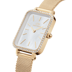 Quadro Lumine Bezel Evergold MOP gold watch with a rectangular case, crystal-set bezel, white mother of pearl dial, and slim gold mesh strap, shown in a close-up highlighting its elegant detailing.
