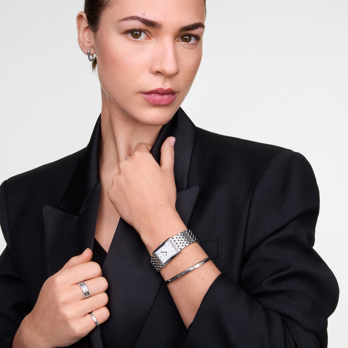 Woman wearing the Classic Aura Duo Ring Silver styled with a sleek black blazer, showcasing the ring’s double row of cubic zirconia crystals and minimalist silver band as part of a modern, elegant jewellery look.