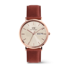 Classic men's watch with a rose gold stainless steel case, champagne dial featuring a subtle triangle pattern, clear day and date display, and a brown genuine leather strap.
