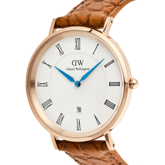 Close-up of the Classic Roman Numerals Date Light Brown Croc Belly Rose Gold watch, highlighting the rose gold case, white dial with black Roman numerals, blue hands, date window at six o’clock, and textured light brown croc-embossed leather strap.
