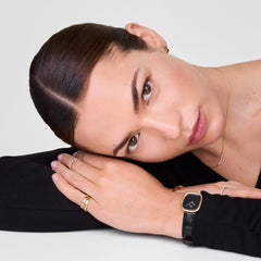 Margot Reading Onyx Ceramic Gold ladies watch worn on the wrist, showcasing its slim gold-tone rectangular case, minimalist black dial, and black croco-embossed leather strap paired with gold rings for a refined, everyday look.