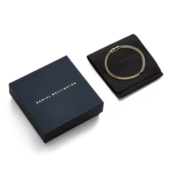 Tide Mesh Necklace Gold 1.8 displayed coiled on a black pouch next to a Daniel Wellington gift box, highlighting its elegant gold mesh chain and premium packaging, ideal for gifting.