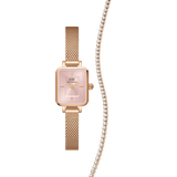 Rose gold Daniel Wellington Quadro Mini Blush Melrose watch with a soft pink rectangular dial and mesh strap, paired with a sparkling tennis bracelet featuring clear stones, styled as a coordinated jewellery set for women.