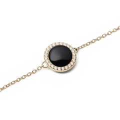 Close-up of the Audrey Bracelet Black Agathe Gold showing a domed black agate stone set in a gold bezel, surrounded by a halo of sparkling white crystals on a fine gold chain.