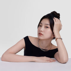 A woman wearing the Contrast Link Earrings Two Tone Rose Gold, styled with a matching two-tone chain necklace and bracelet, paired with a black off-shoulder top for a modern, minimalist look.