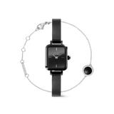 Rectangular black Daniel Wellington Quadro Mini watch with a slim black mesh strap, paired with a delicate silver Audrey Black bracelet featuring a round black stone pendant framed by sparkling details.