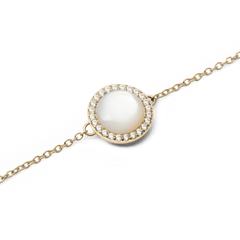 Close-up of the Audrey Bracelet Mother of Pearl Gold showing its domed mother of pearl centrepiece surrounded by a halo of sparkling white cubic zirconia on a slim gold chain.