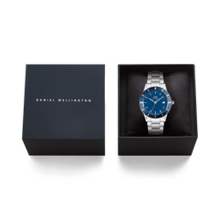 Iconic Paradigma Link Blue Enamel Silver men’s watch with a blue enamel dial and stainless steel bracelet, elegantly presented in a Daniel Wellington gift box.