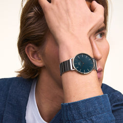A man wearing the Classic Piano Link Arctic Silver watch with a brushed arctic blue dial and stainless steel piano link strap, styled with a casual blue jacket and white T-shirt for a relaxed, modern look.