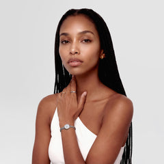 A woman wearing the Line Ring Polished Silver 2.5mm on her finger, styled with a minimalist silver watch and a white sleeveless top, showcasing the ring’s slim, polished design as part of an elegant everyday look.