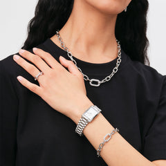 Woman wearing the Crystal Link Ring Silver on her finger, styled with matching chain link necklace and bracelet, and a silver watch, showcasing a coordinated modern jewellery look.
