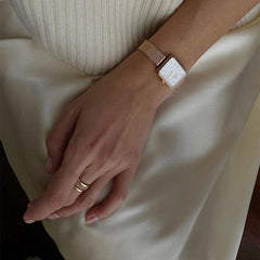 A woman’s hand wearing the Elan Dual Ring Rose Gold, styled with a matching rose gold watch, highlighting the ring’s double-band design and minimalist elegance for everyday wear.