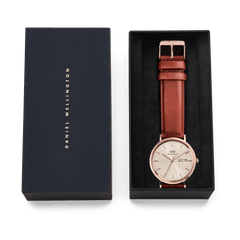 Classic Day Display St Mawes Rose Gold Champagne men's watch with a champagne dial, rose gold case, and brown leather strap, presented in a Daniel Wellington gift box.